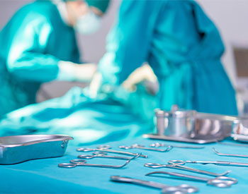 Surgical instruments and tools including scalpels, forceps, and tweezers arranged on a table for surgery, operating room with surgery equipment, preparing medical instruments for operation.